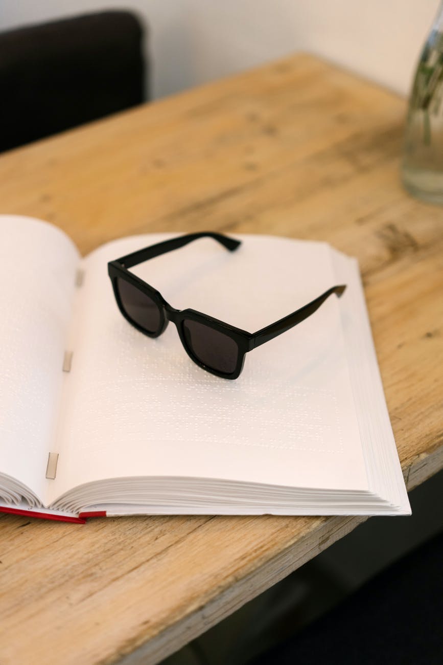black framed sunglasses on white book page